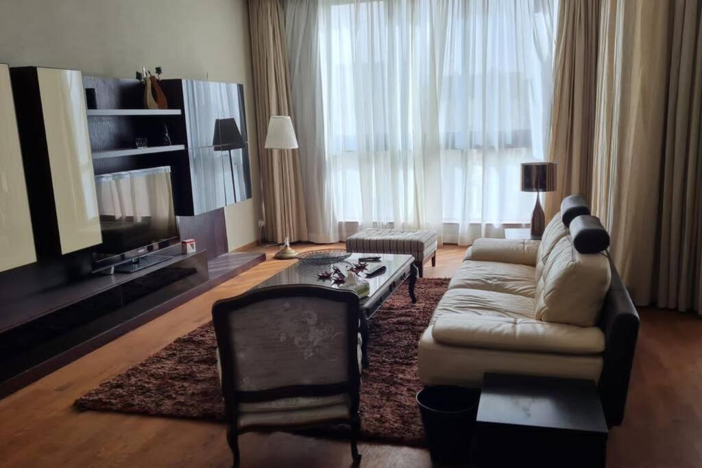 a living room with a couch and a tv at Aeon Towers Luxury Apartment in 6th Of October