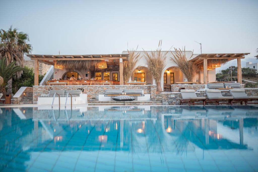 a swimming pool with chairs and a resort at Yialos Ios Hotel in Ios Chora