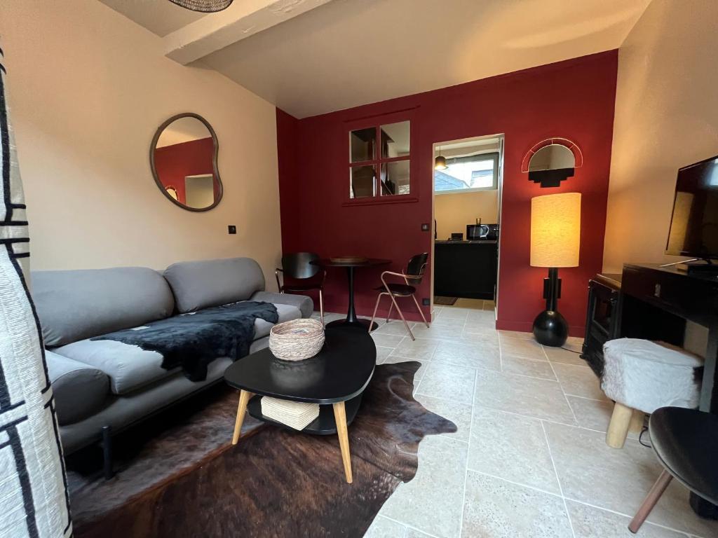 ein Wohnzimmer mit einem Sofa und einem Tisch in der Unterkunft La Mondaine - idéalement situé, charme in Honfleur