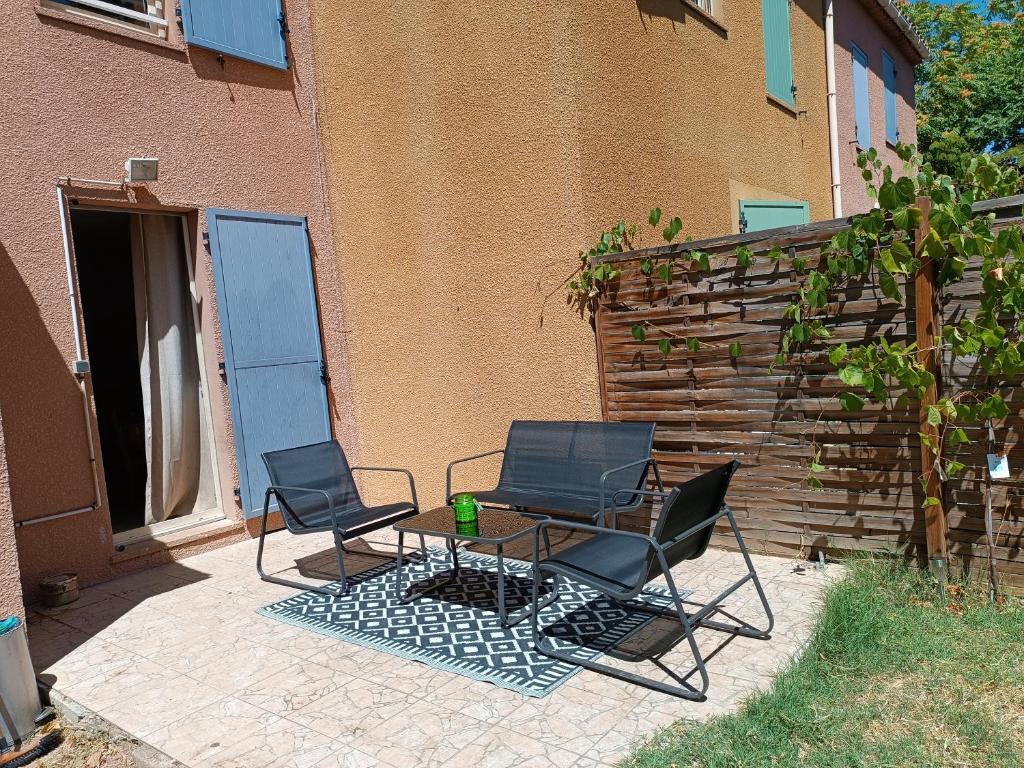 two chairs and a table in front of a building at Villa Mont D'Or in Manosque