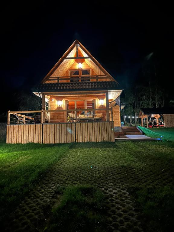 a large wooden house with lights on it at night at GRABNIK55 in Krasnobród