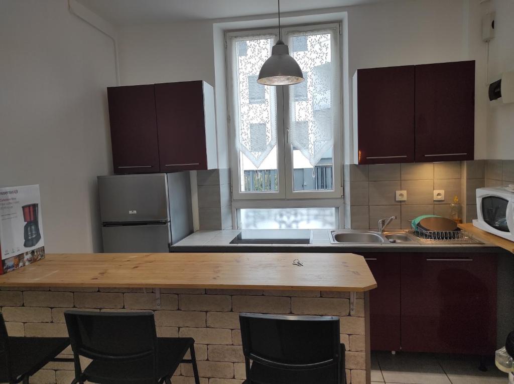 une cuisine avec un îlot en bois au milieu dans l'établissement Beau F3 proche hôpital central, Nancy thermal, à Nancy