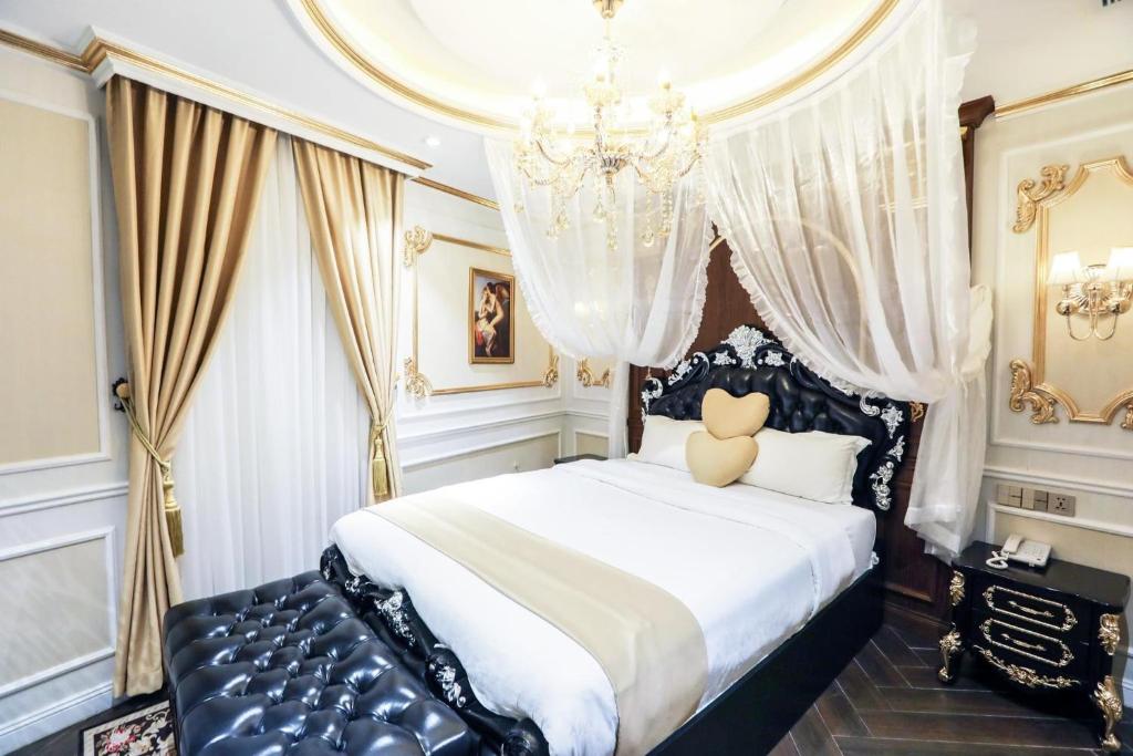 a bedroom with a large bed with a chandelier at ENJOY HOTEL 2 in Ho Chi Minh City