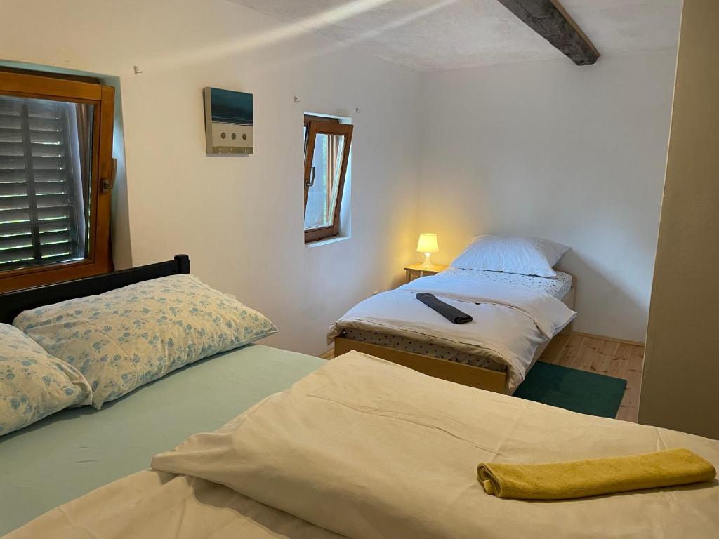 - une chambre avec 2 lits et une fenêtre dans l'établissement Wooden house Mali Vrh, à Kamanje