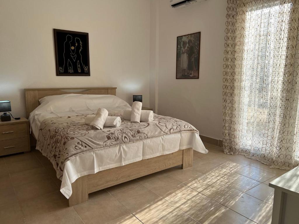 una camera da letto con un letto con lenzuola bianche e una finestra di Suburban Oasis a Alexandroupoli