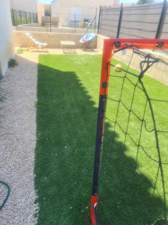 a batting cage in a yard with grass at Chez Riz in Arles