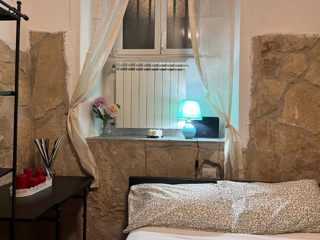 ein Schlafzimmer mit einem Bett und ein Fenster mit einer Lampe in der Unterkunft Cowsin House in Rom