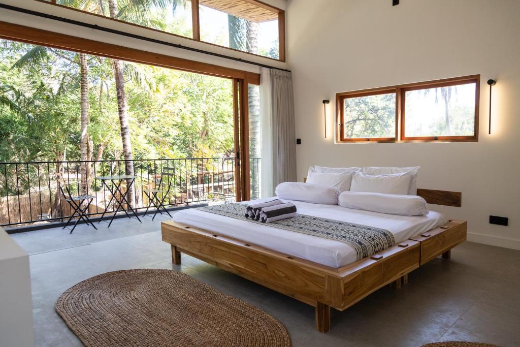 1 dormitorio con 1 cama grande y balcón en Villa Luna - Gili Air, en Gili Air