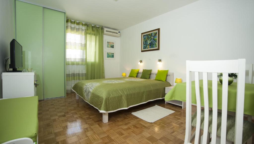 zieloną sypialnię z łóżkiem i telewizorem w obiekcie Green Place w Splicie