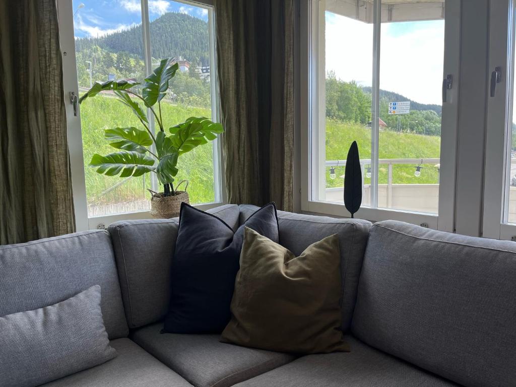 eine graue Couch mit Kissen vor dem Fenster in der Unterkunft Åre Travel- Freestyle in Åre