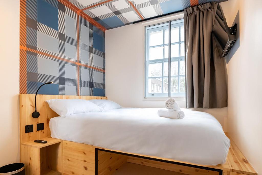a small bedroom with a bed and a window at easyHotel Paddington in London