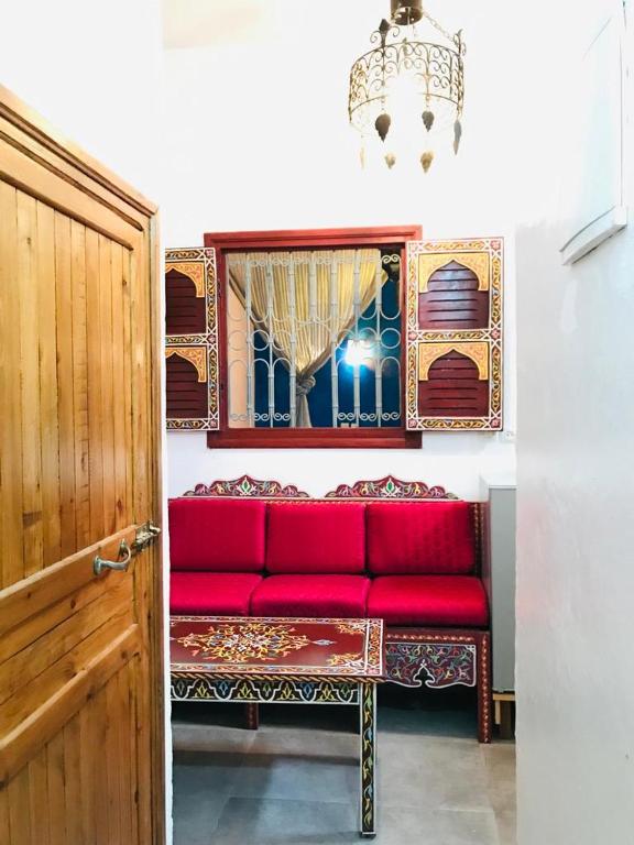 - un canapé rouge dans une chambre avec fenêtre dans l'établissement Dar MTOGUI, à Rabat