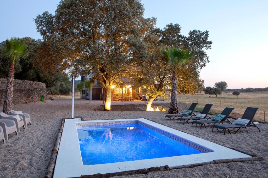 una piscina en medio de un patio con sillas y árboles en Finca San Benito, piscina privada, a estrenar!, en Mejorada