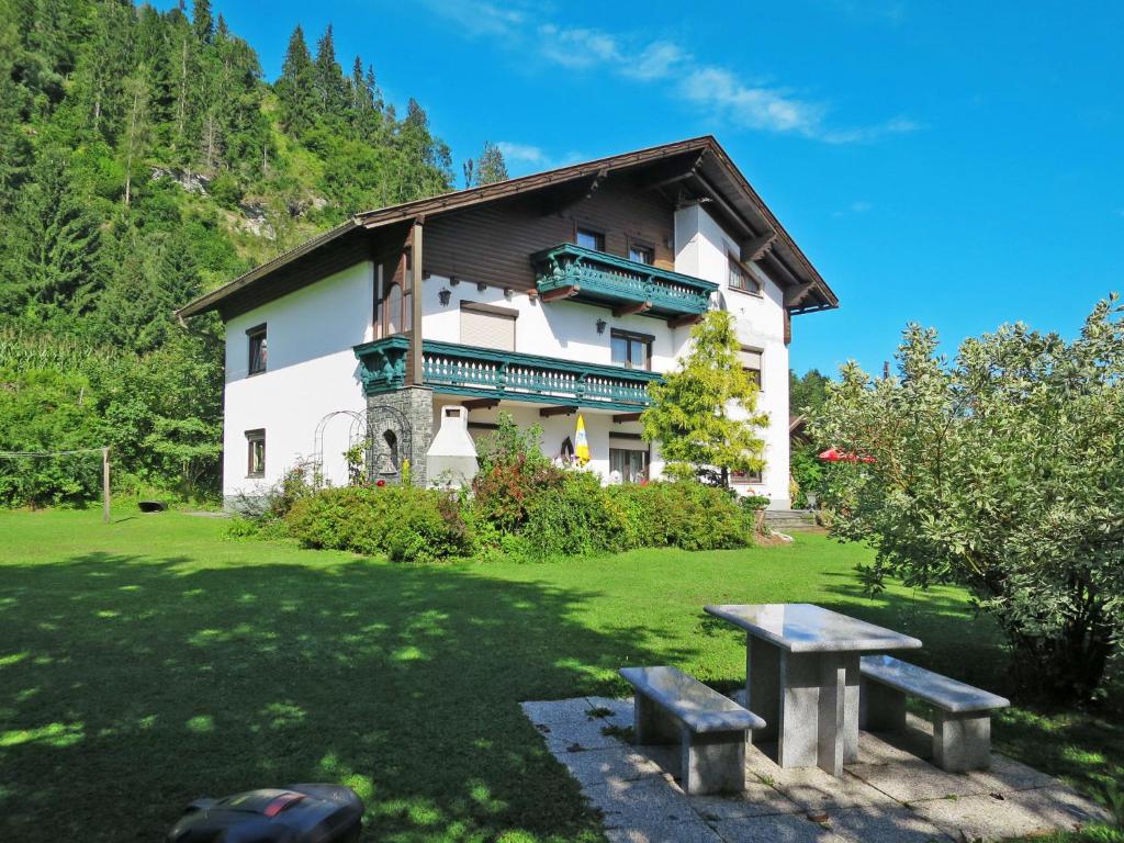 un edificio con una mesa de picnic delante de él en Apartment Alpenrose-4 by Interhome, 