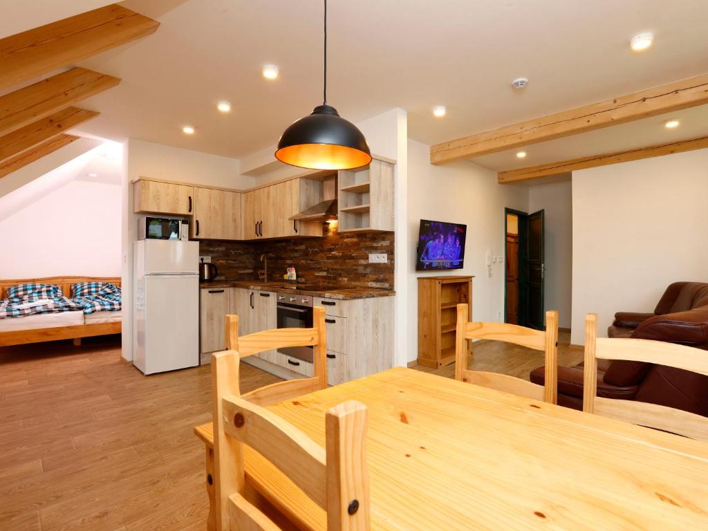 een keuken en een woonkamer met een houten tafel en stoelen bij Apartment Hora Jizera by Interhome in Desná