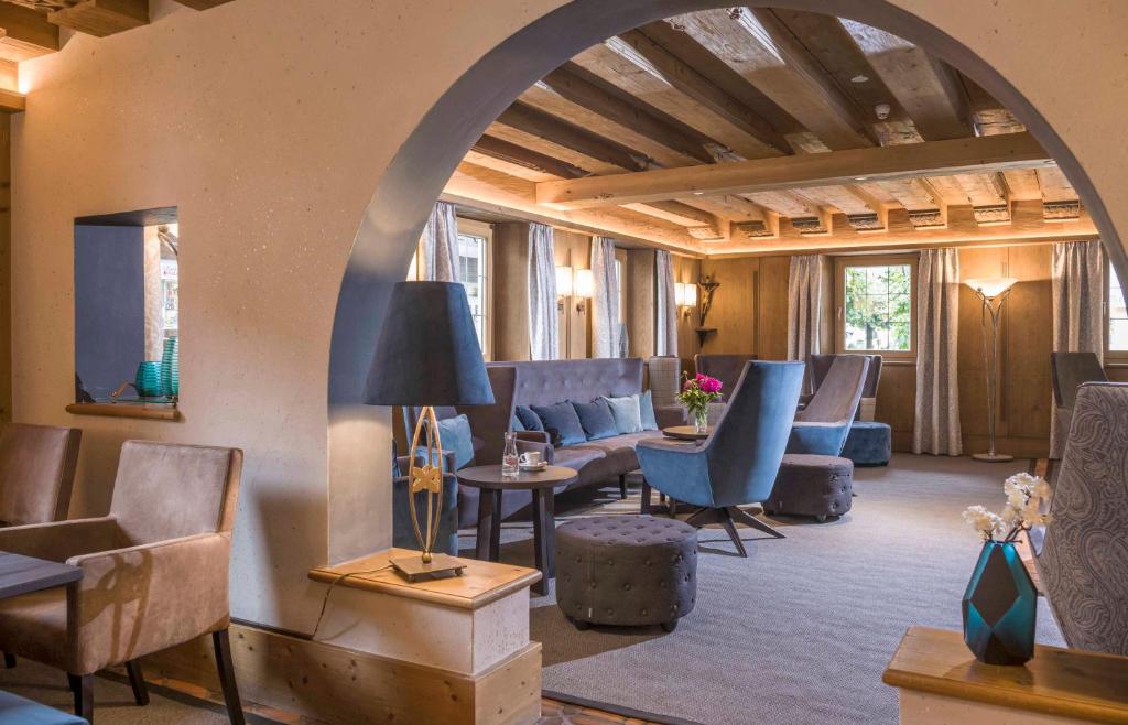 an archway in a room with couches and chairs at Hotel Jakobwirt in Westendorf