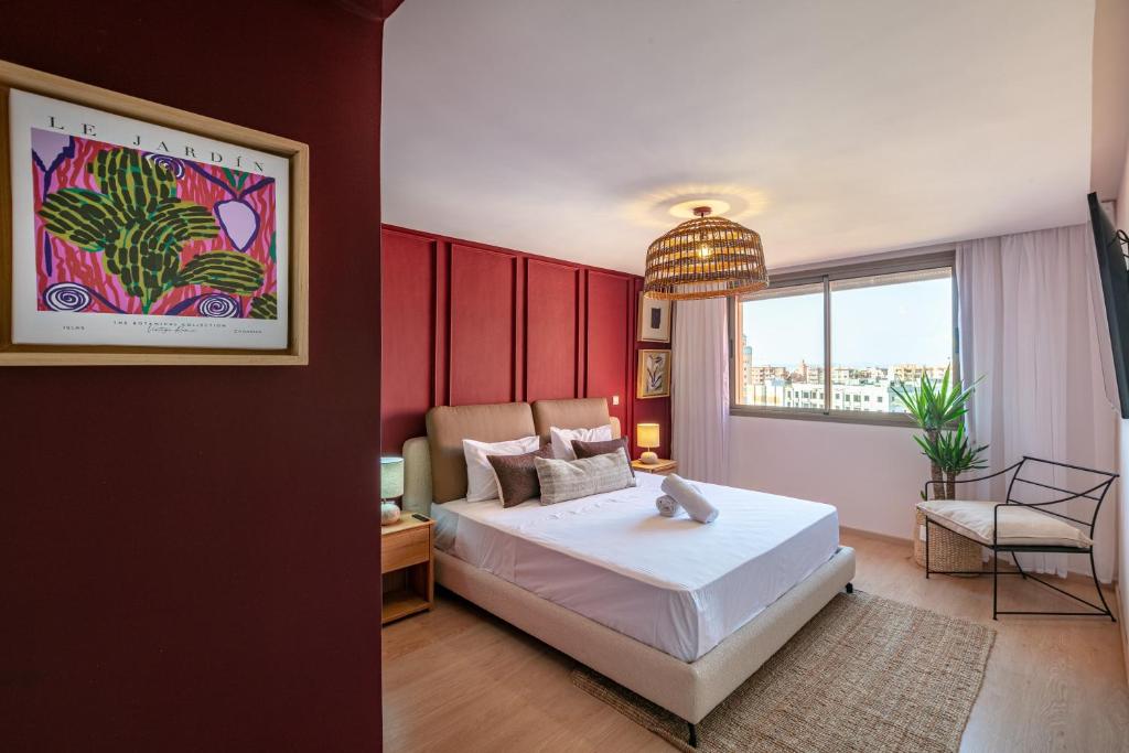 ZARI BOUTIQUE ApartHotel في مراكش: غرفة نوم بسرير ابيض كبير وكرسي
