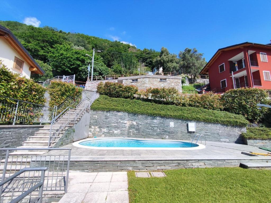 una piscina en un patio junto a una pared de ladrillo en Apartment Lakeview Le Vele by Interhome, en San Siro
