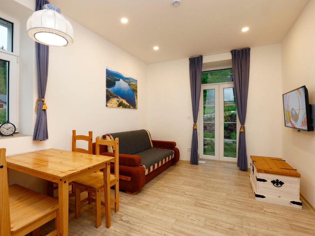 a living room with a couch and a table at Apartment Přehrada Souš by Interhome in Desná