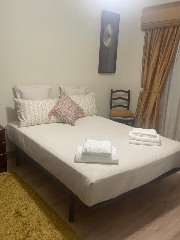 a bed with two towels on top of it at Guest House “Casa da avó Tina” in Barreiro