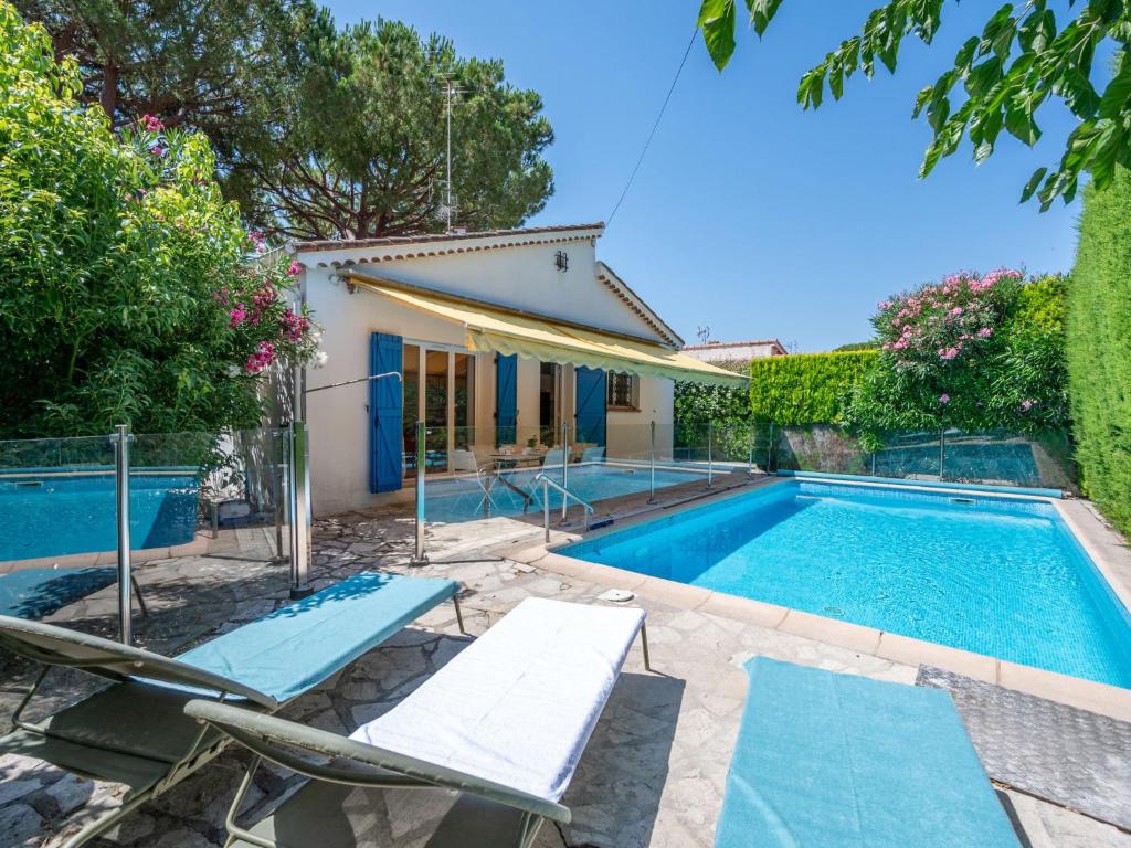 マンドリュー・ラ・ナプールにあるVilla La Vigne by Interhomeの椅子と家のあるプール