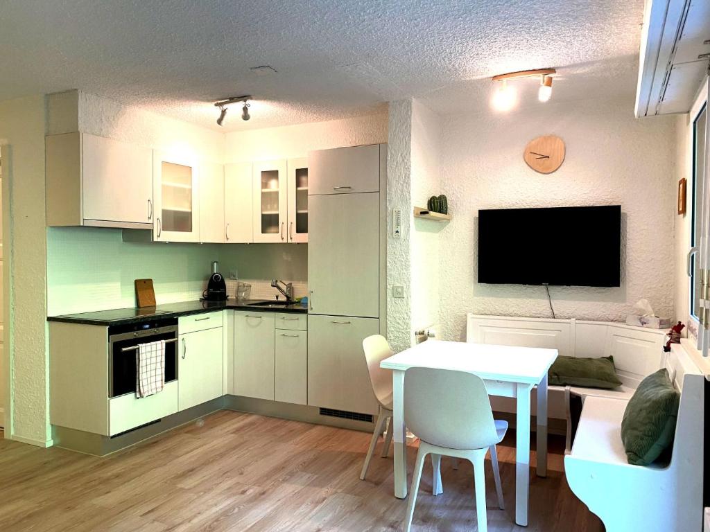 a kitchen and dining room with a table and a tv at Studio Les Dauphinelles by Interhome in Les Collons