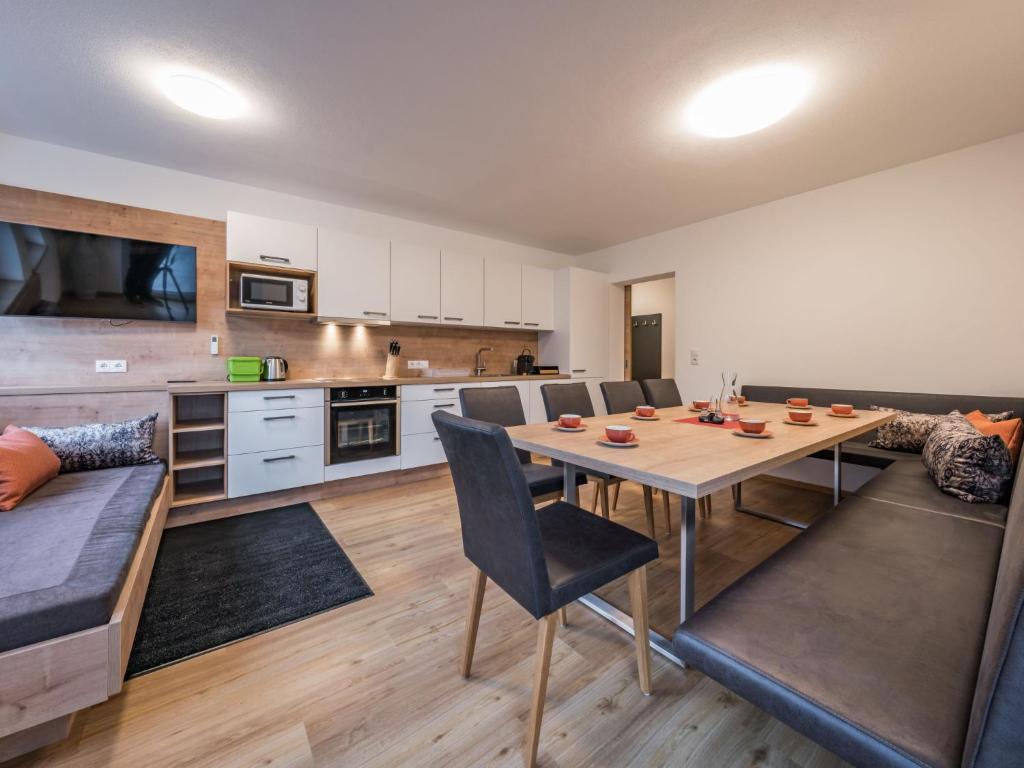 cocina y sala de estar con mesa y sillas en Apartment Montec-3 by Interhome, en Hippach
