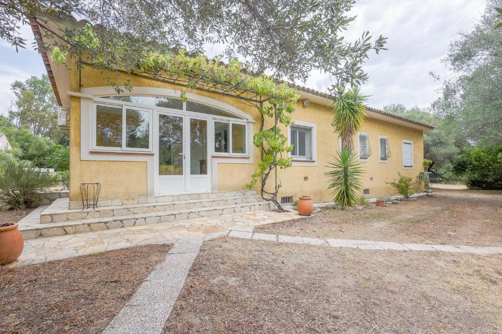 une maison jaune avec une porte blanche et des fenêtres dans l'établissement Villa Ventiseri - Maison vue montagne, à Ventiseri