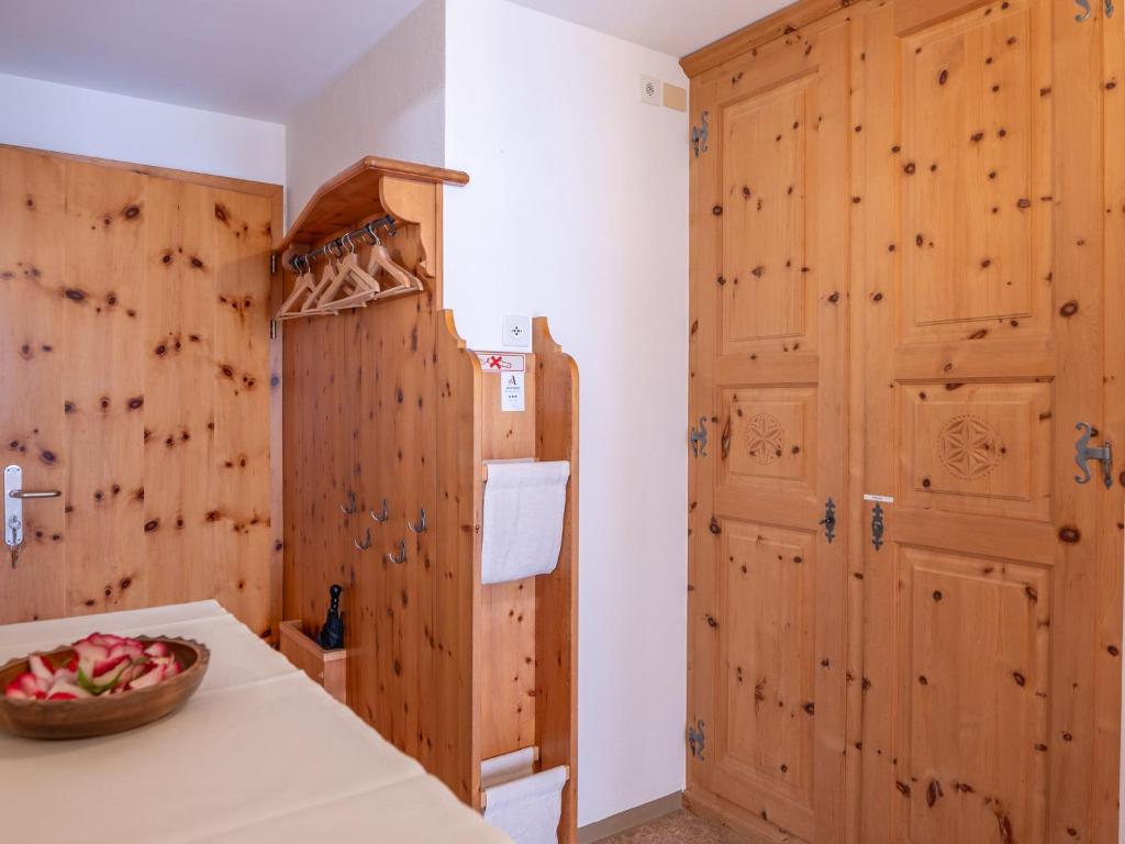 a kitchen with wooden walls and a table and a door at Apartment Chesa Muntarütsch by Interhome in Samedan