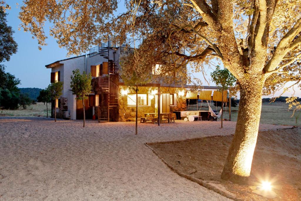 una casa con un árbol delante de ella en Finca San Benito, piscina privada, a estrenar!, en Mejorada