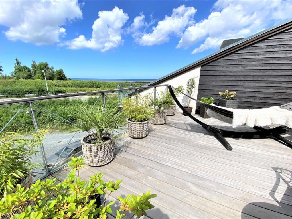 una terraza con plantas y una hamaca en una casa en Apartment Bena - 150m from the sea in Sealand by Interhome, en Dronningmølle