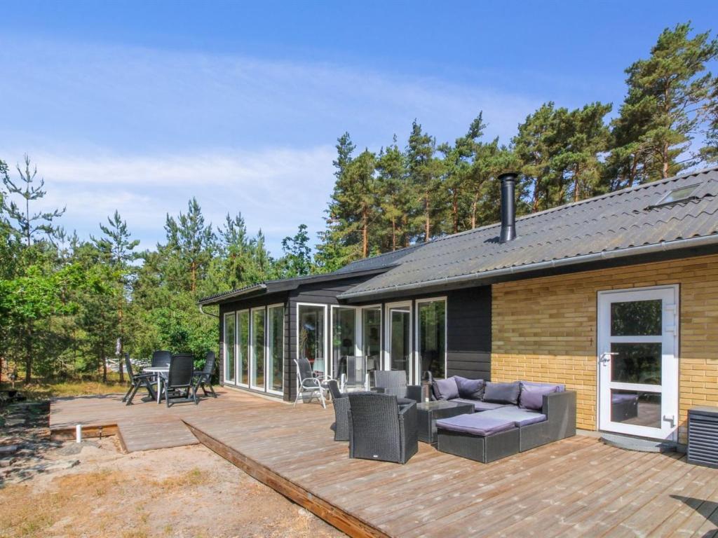 eine Terrasse mit einem Sofa und Stühlen auf einem Haus in der Unterkunft Holiday Home Gudmand - 600m from the sea in Bornholm by Interhome in Vester Sømarken