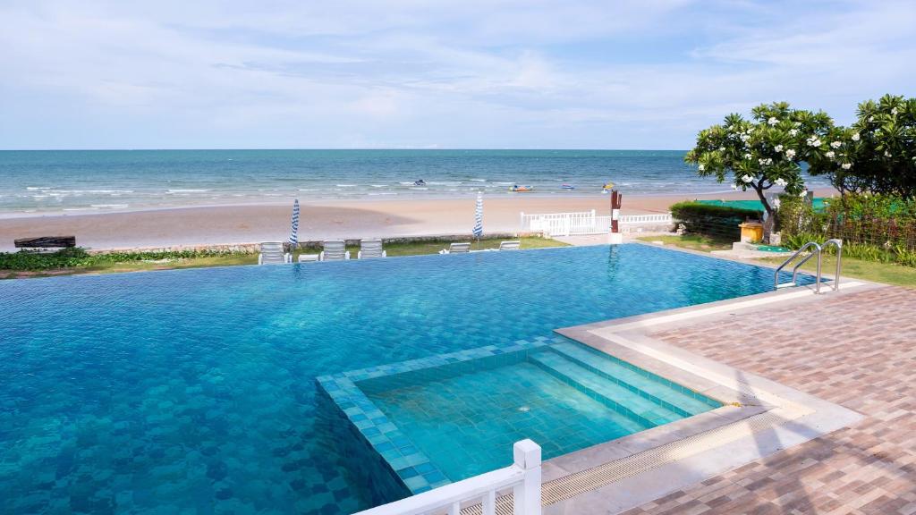 a large swimming pool next to a beach at Baan Poolom Beachfront Condominium in Hua Hin