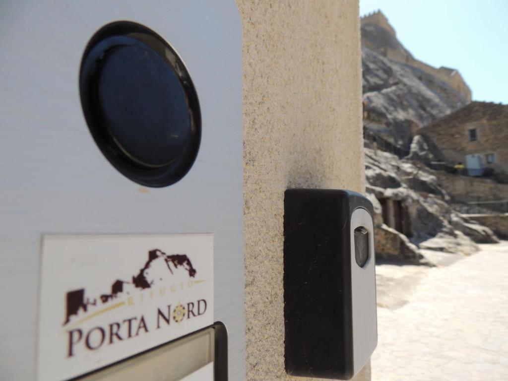 un orologio sul lato di un palo con un cartello di Rifugio Porta Nord a Sperlinga