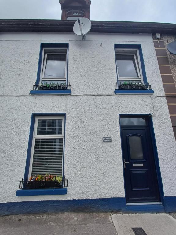 un edificio blanco con dos ventanas y una puerta en Tirchonaill Townhouse, en Donegal