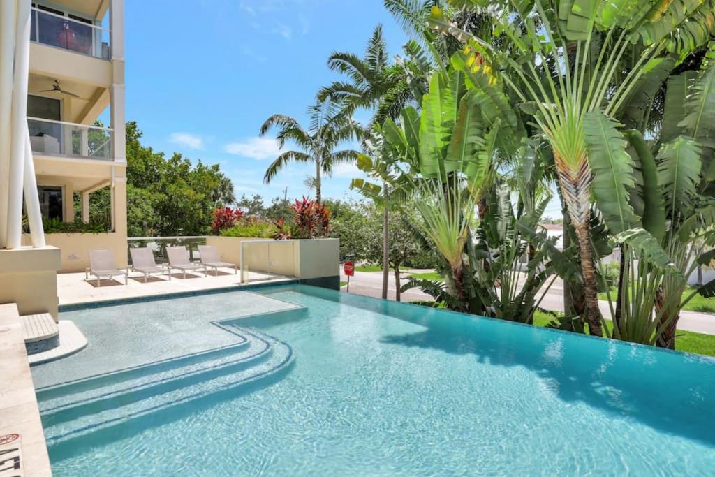 uma piscina num resort com palmeiras em Coastal Condo Deerfield Beach Retreat 3 bed 2 bath em Deerfield Beach