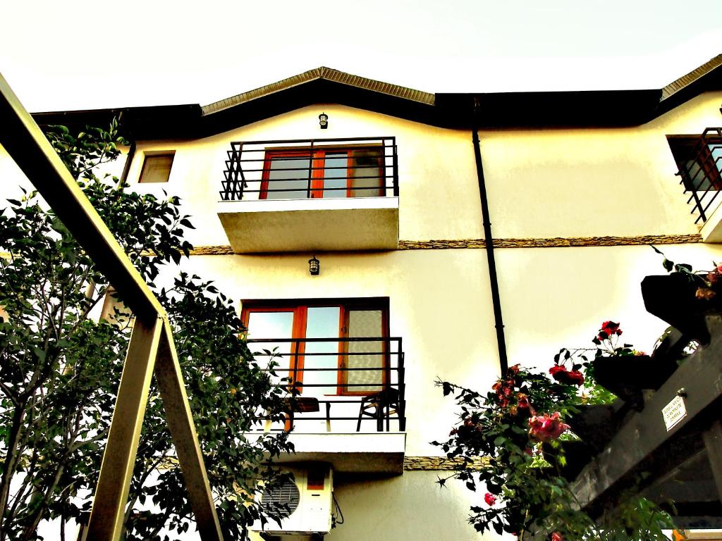 a white building with a balcony and flowers at Vita de vie estival in Costinesti
