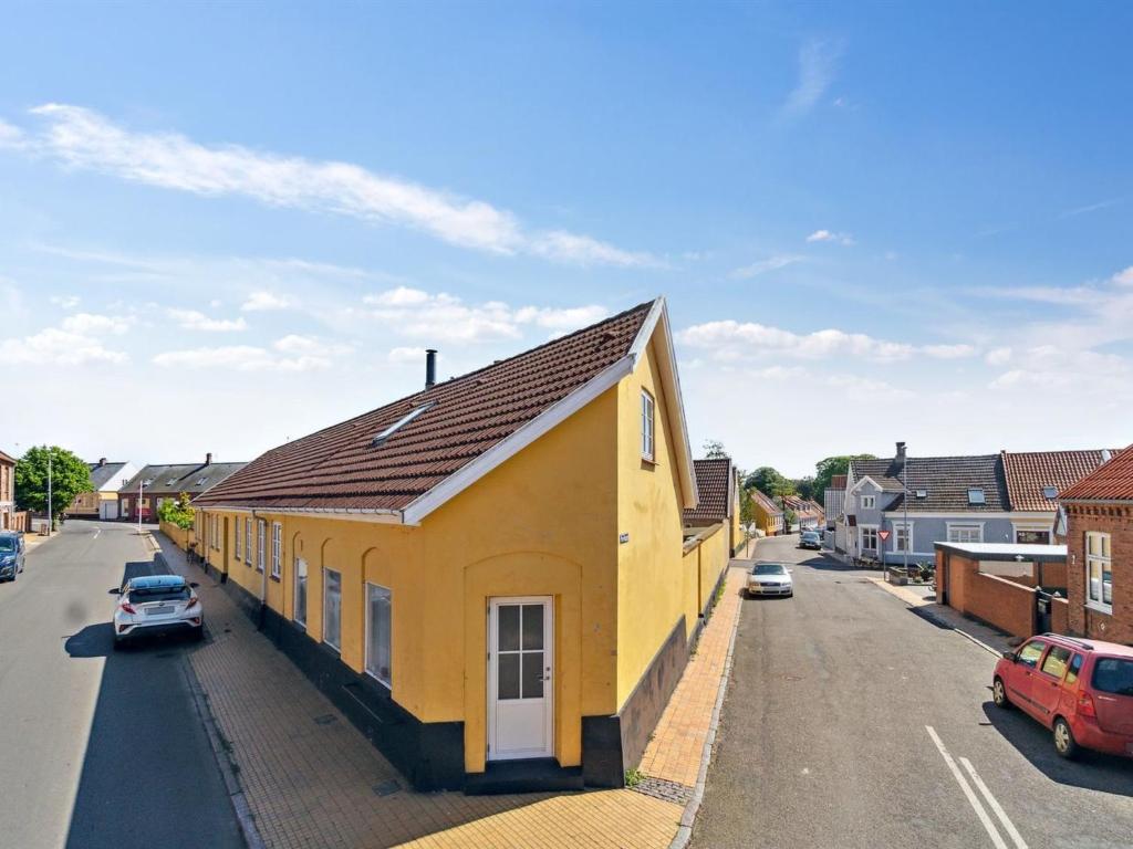 a yellow house on the side of a street at Apartment Dagne - 400m from the sea in Bornholm by Interhome in Hasle