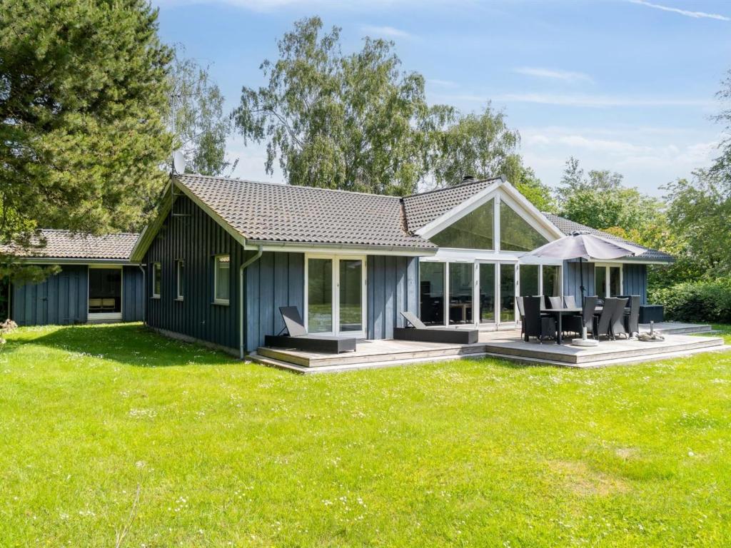 a blue house with a large yard at Holiday Home Josina - 675m from the sea in Sealand by Interhome in Tjørneholm