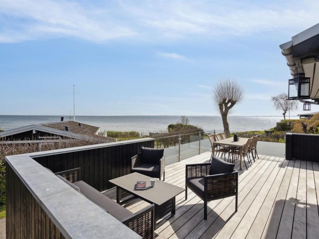 a wooden deck with chairs and a table on the beach at Holiday Home Steen - 30m from the sea in Funen by Interhome in Vejstrup
