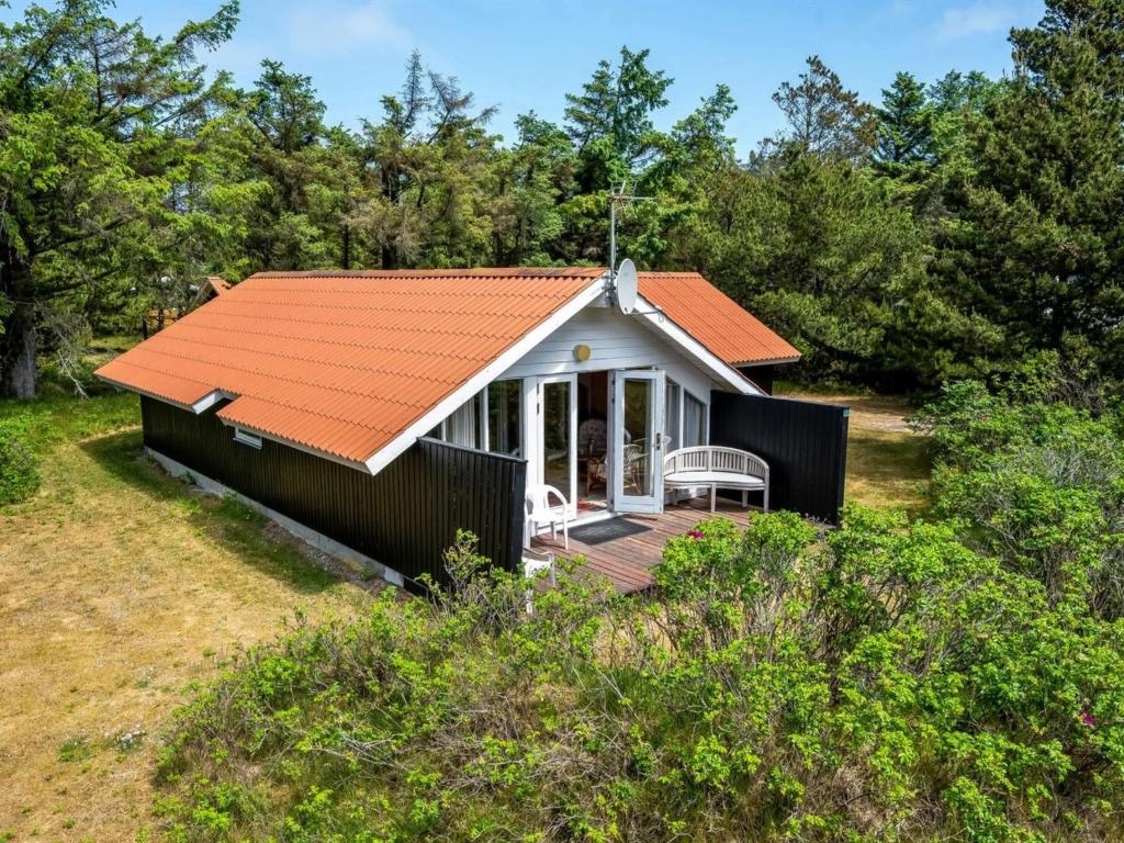 una pequeña casa con techo naranja en Holiday Home Clea - 800m from the sea in Western Jutland by Interhome en Vejers Strand