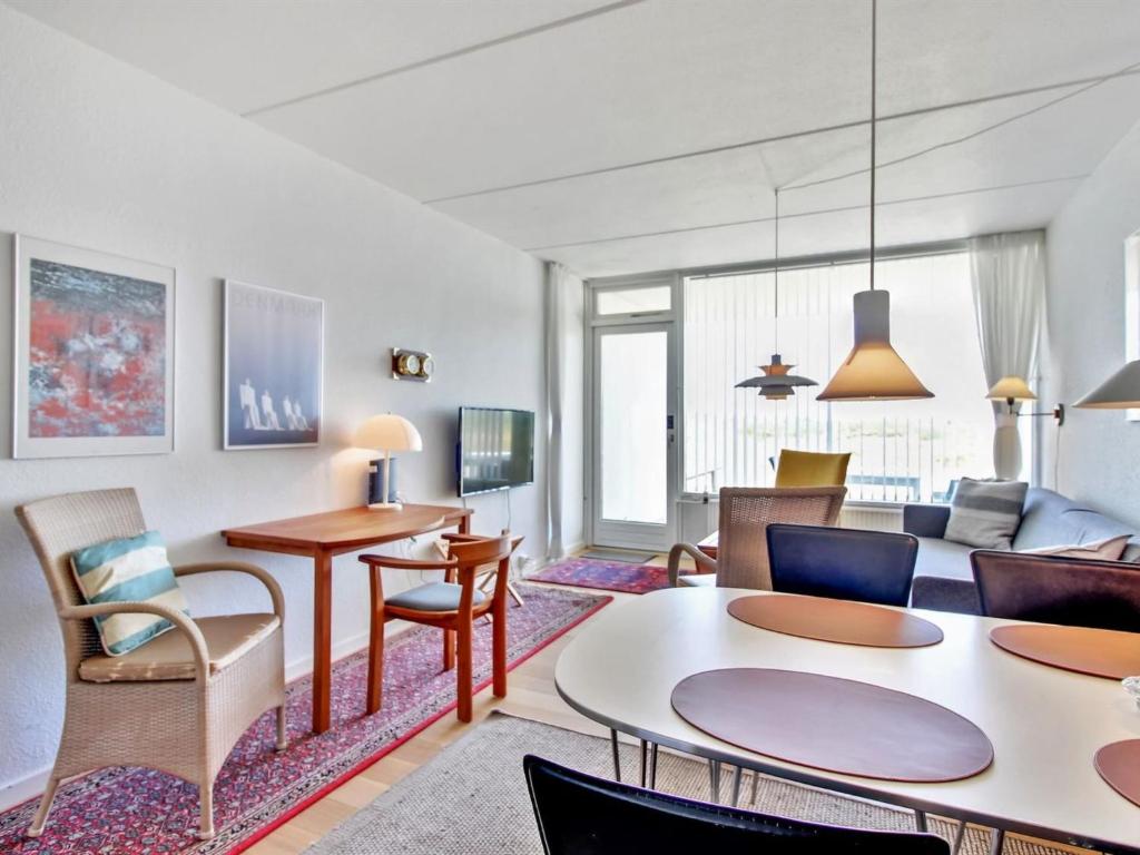 uma sala de estar com um sofá, uma mesa e cadeiras em Apartment Eske - 50m from the sea in Western Jutland by Interhome em Fanø
