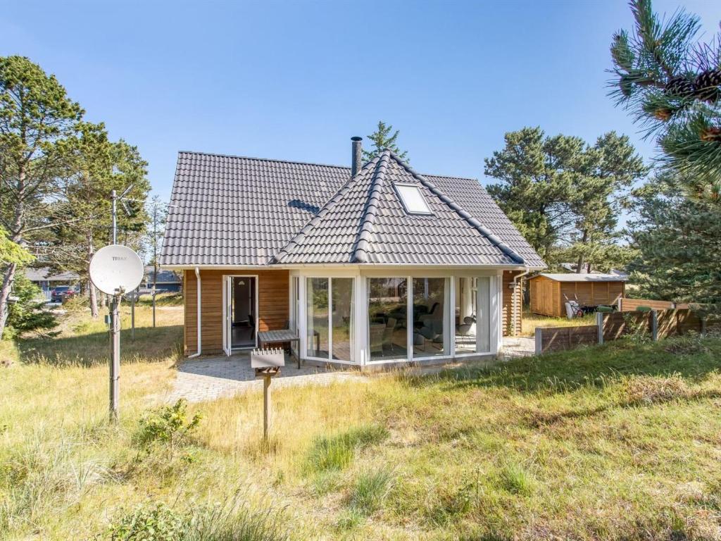 a small house on a grassy hill with a satellite at Holiday Home Laila - all inclusive - 1-2km from the sea in Western Jutland by Interhome in Vejers Strand