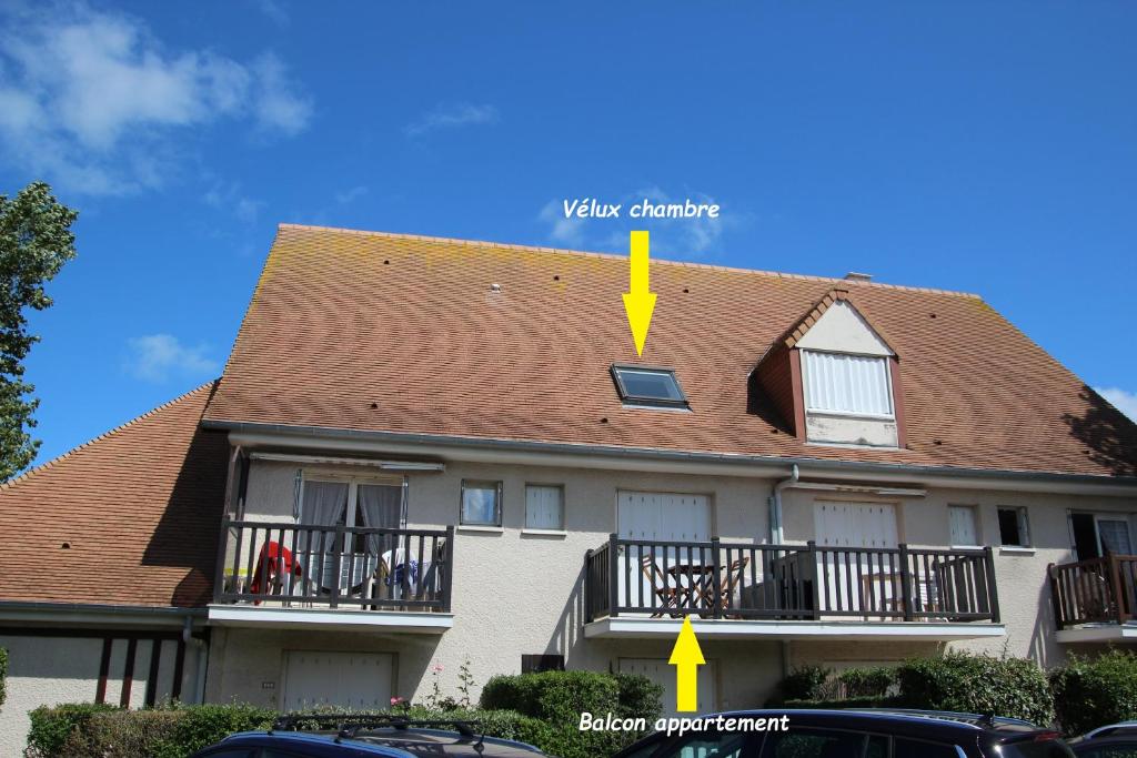 un techo de una casa con una flecha amarilla apuntando a un edificio en Appartement Côte Fleurie - MERVILLE FRANCEVILLE PLAGE, en Merville-Franceville-Plage