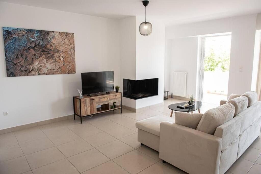 sala de estar con sofá y TV en Overlooking park flat close to the Piraeus Port-(DRAP-A7), en Pireo