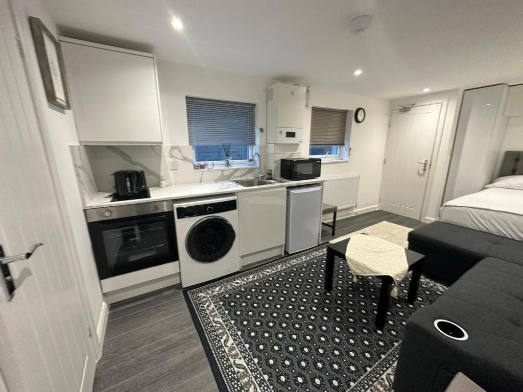 a room with a kitchen and a living room at Centrally located private studio flat in Luton in Luton