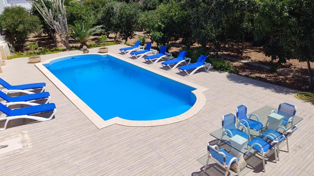 a group of chairs and a swimming pool at Stunning Villa with Pool, Table tennis, Table soccer and a Pool table in Naxxar
