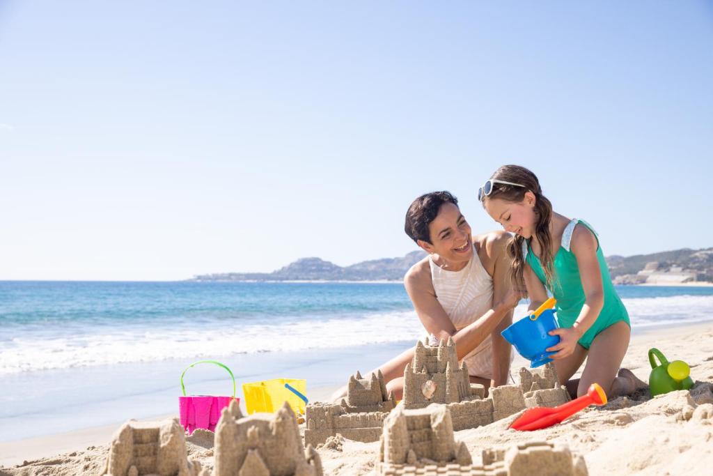 a woman and a girl playing with a sand castle on the beach at Hyatt Ziva Los Cabos - All Inclusive in San José del Cabo