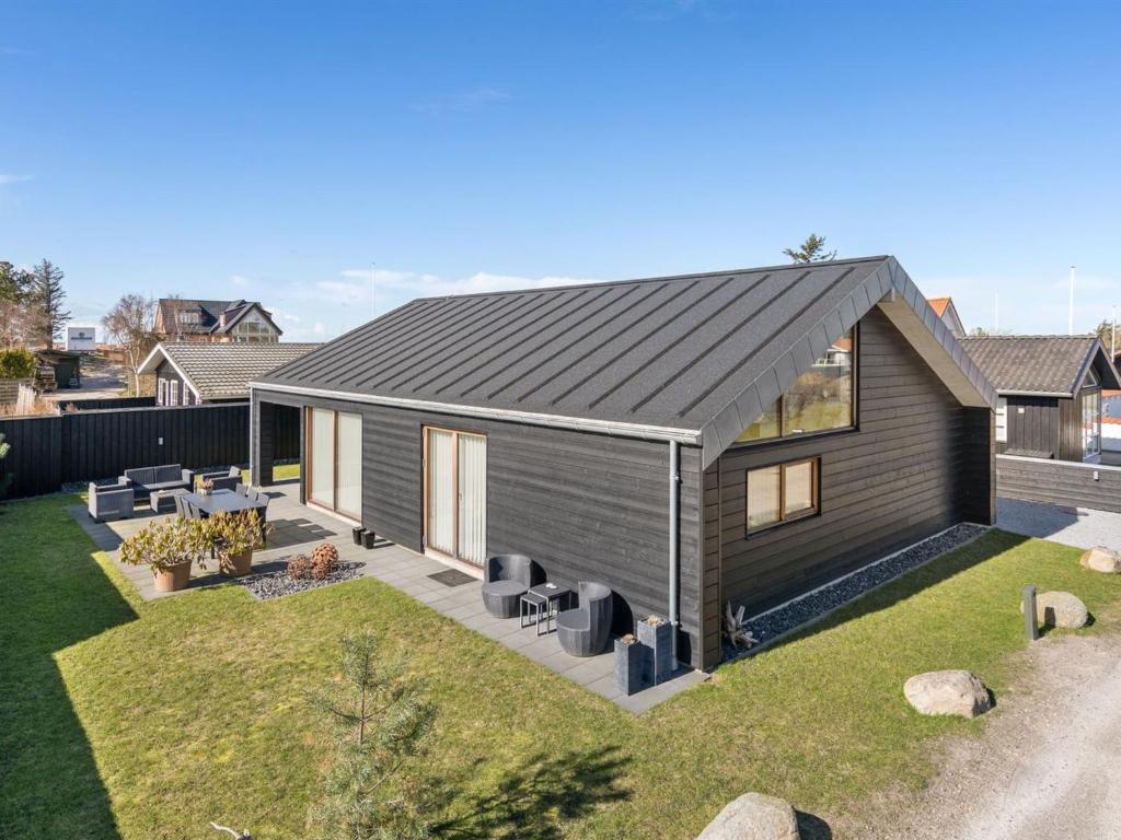 une petite maison avec un toit gris sur une cour dans l'établissement Holiday Home Aaran - 700m from the sea in NW Jutland by Interhome, à Blokhus