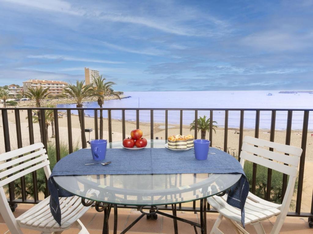 a table with a bowl of fruit on a balcony with the beach at Apartment Riells Platja by Interhome in L'Escala